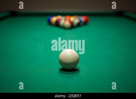 Sport billiard balls set arranged in shape of triangle on green billiard table in pub Stock Photo
