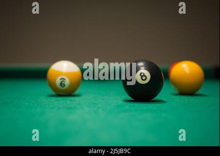 Sport billiard balls set arranged in shape of triangle on green billiard table in pub Stock Photo