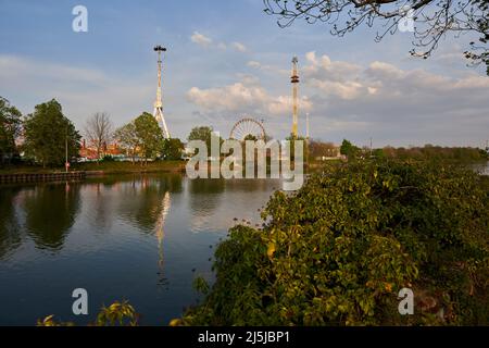 Stuttgart, Germany - April 22, 2022: Spring festival (Frühlingsfest) with Fun rides and carousels by the river at evening. Germany, Stuttgart, Wasen. Stock Photo