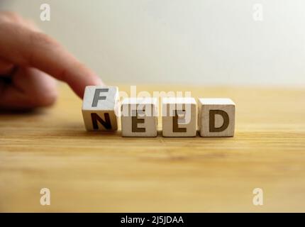 Need to feed concept. Hand flips letter on wooden cube changing the word need to feed. Message for food assistance, famine eradication, children malnu Stock Photo