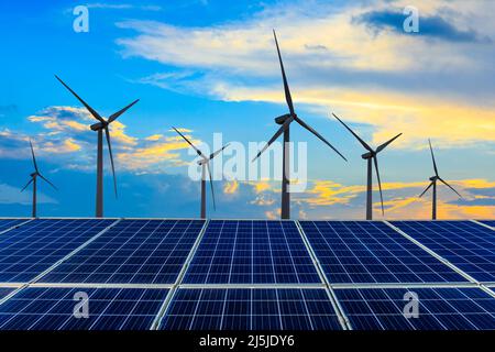 Wind turbines and solar panels at sunset. renewable energy concept. Stock Photo