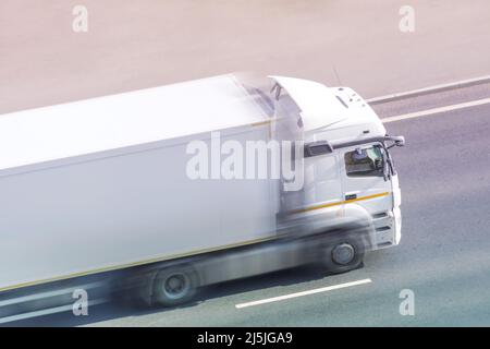 White box truck driving fast with blank space for text on a highway city road. Stock Photo