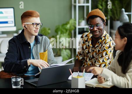 Portrait of young creative team collaborating in business meeting while enjoying work on project together Stock Photo