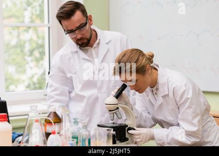 Two scientist colleagues are using microscope during research work in a laboratory Stock Photo