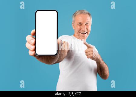 Excited mature man pointing finger at empty smartphone screen Stock Photo