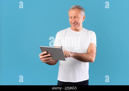 Confident mature man holding and using tablet Stock Photo