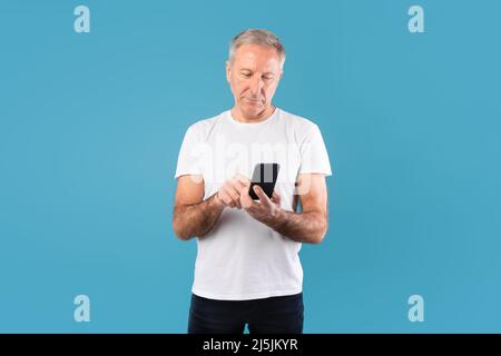 Mature man using his mobile phone at studio Stock Photo
