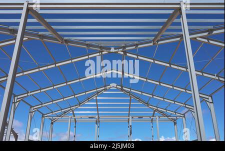 detail of the metal structure of a building or ship in the middle of the construction with blue and cloudy sky Stock Photo