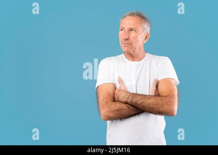 Serious mature man crossing arms posing at camera Stock Photo
