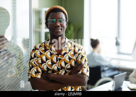 Waist up portrait of black young man wearing bright yellow pattern in office and looking at camera while posing confidently,copy space Stock Photo