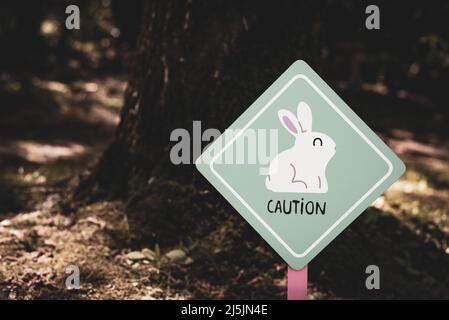 Funny sign inside a forest. Caution: rabbits. Easter mood. Stock Photo