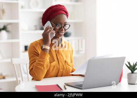 Stylish african american woman in turban working from home Stock Photo