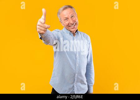 Happy mature man pointing finger at camera at studio Stock Photo