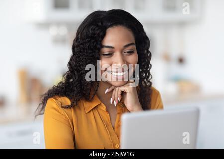 Closeup of happy black woman using digital tablet at home Stock Photo