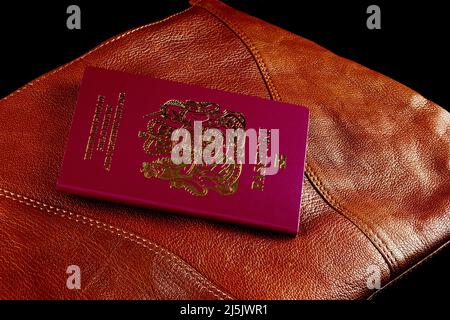 Leather shoulder bag with passport on a black background Stock Photo