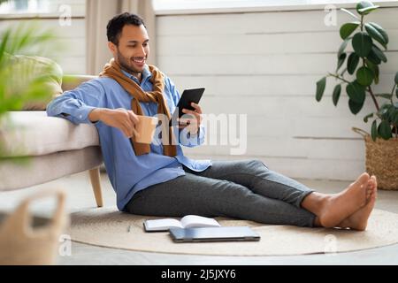 Portrait of smiling young man using tablet at home Stock Photo