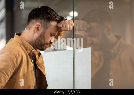 Depressed Businessman Standing Near Door Having Business Problem In Office Stock Photo