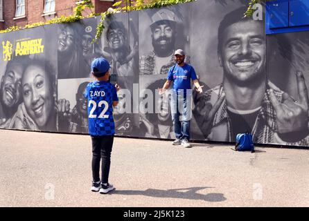 Chelsea fans pose for a picture in front of a family portrait mural outside the ground ahead of the Premier League match at Stamford Bridge, London. Picture date: Sunday April 24, 2022. Stock Photo