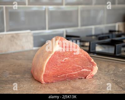 joint of uncooked beef  on a kitchen worktop Stock Photo