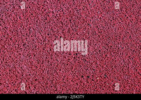 Red synthetic carpet texture background Stock Photo