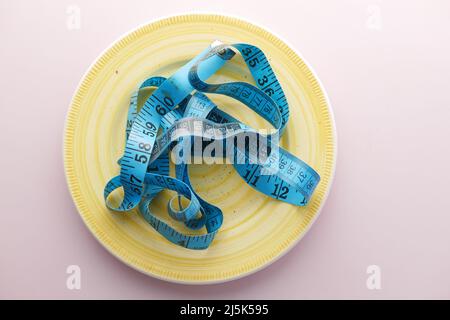 Clean plate with measurement tape on table  Stock Photo