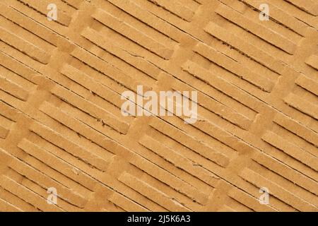 Perforated wrapping recycled brown paper. Corrugated grunge eco material with geometrical line pattern. Abstract background Stock Photo