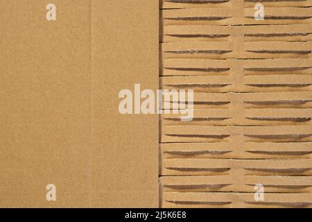 Perforated wrapping recycled brown paper. Corrugated grunge eco material with geometrical line pattern and copy space. Abstract background Stock Photo