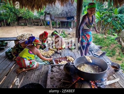 Embera Puru indian woman are preparing and frying plantain in the Embera Puru village beside Rio Pequeni, Republic of Panama, Central America. Stock Photo