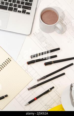 Mockup of architectural concept, Drawing tool and coffee on drawing of blueprint with safety helmet. Stock Photo