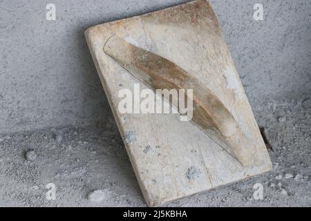 Wooden trowel used for planing concrete surface after plastering. The old way of construction using wooden tools Stock Photo