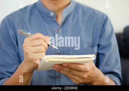 Businessman holding a pen and a notebook to take notes and plan ideas. Stock Photo
