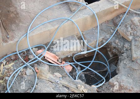 Water hose in under construction site with some of the parts fallen inside a small pit Stock Photo