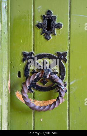 Green painted wooden church door with rusted ring handle Stock Photo