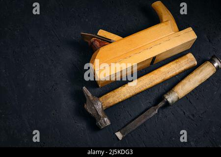 Set of tools for carpenters, hammer, chisel and plane on dark background Stock Photo