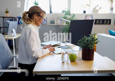 Elegant mature business woman working on computer in the office Stock Photo