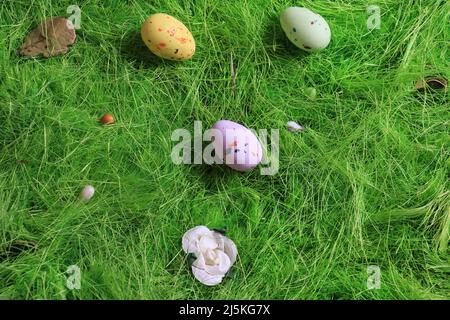 Pastel colored Easter chocolate eggs on green grass. Stock Photo