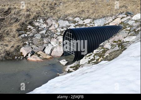 plastic corrugated drainage pipe with grate in winter Stock Photo