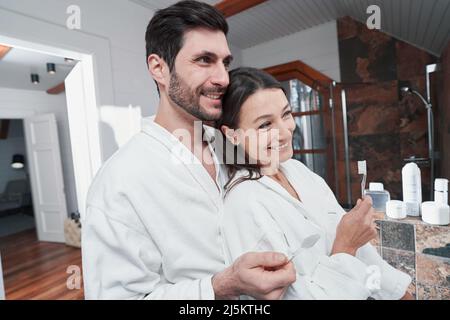 Male laughing with his wife during brushing of teeth Stock Photo
