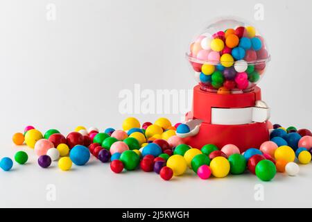 A plastic toy gum ball machine with colourful gum balls all around.