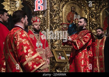 Bucha, Kyiv, Ukraine. 24th Apr, 2022. Priests seen celebrating Easter's service. The Orthodox Easter service at night - from late Saturday night to early Sunday morning- had been celebrated inside St. Michael's Golden Domed Cathedral, in Kyiv, at the presence of the Metropolitan Epifany, the clergy and few people, due to national curfew. The ceremony has been recorded for online streaming for devoted people. (Credit Image: © Valeria Ferraro/ZUMA Press Wire) Stock Photo