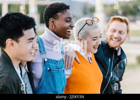 Group of happy best multiracial friends hugging together each other outdoor Stock Photo