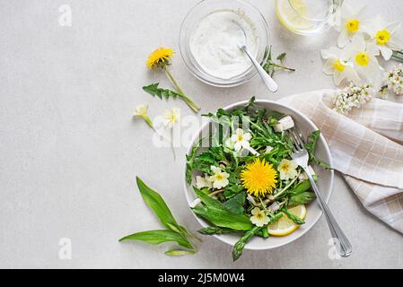 Spring salad with dandelion, asparagus, flowers, nettle and cream cheese. Healthy spring detox food ingredients. Stock Photo