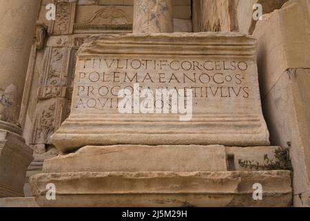 Roman inscription on block of granite at the library of Celsus, Ancient ruins of Ephesus, Turkey. Stock Photo