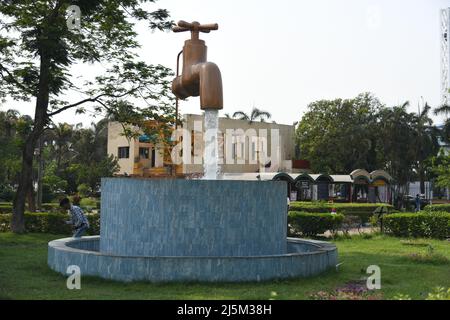 Giant Magic Tap, an outdoor floating tap fountain hovering above a pool, with endless supply of water gushing out of it, seemingly from nowhere. Scien Stock Photo