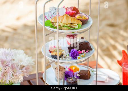 Afternoon tea on tropical sandy beach with shadows from palm trees in summer day Stock Photo