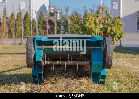 Spring lawn treatment with electric aerator with special blade to prepare for summer season. Sweden. Stock Photo