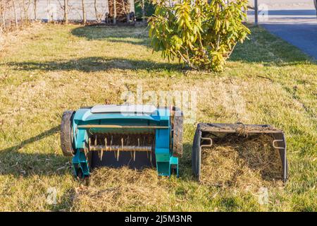 Close up view of electric aerator with basket of collected old grass. Sweden. Stock Photo