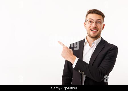 A young businessman in a business suit points to copyspace. Stock Photo