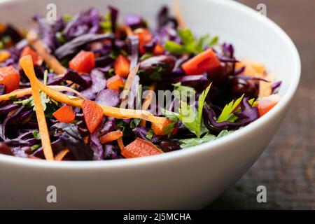Bowl with a home made Kidney Bean and Purple Cabbage Salad with carrots and red bell pepper.