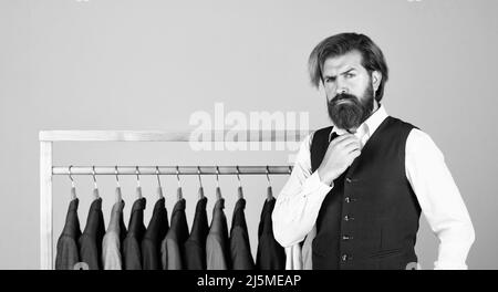 Man picking suit from personal wardrobe, fashion clothes concept Stock Photo